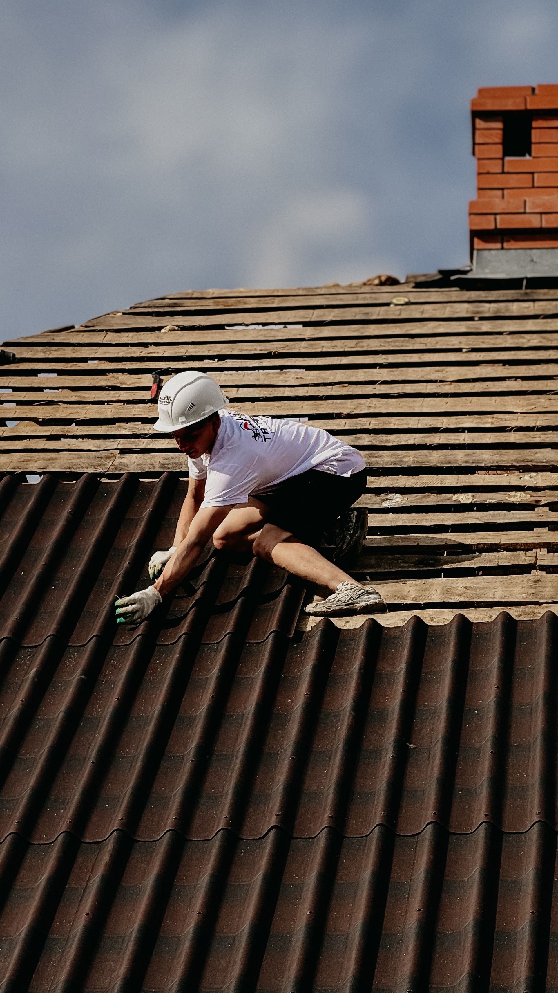 Pokrývač při pokládce střešní krytiny